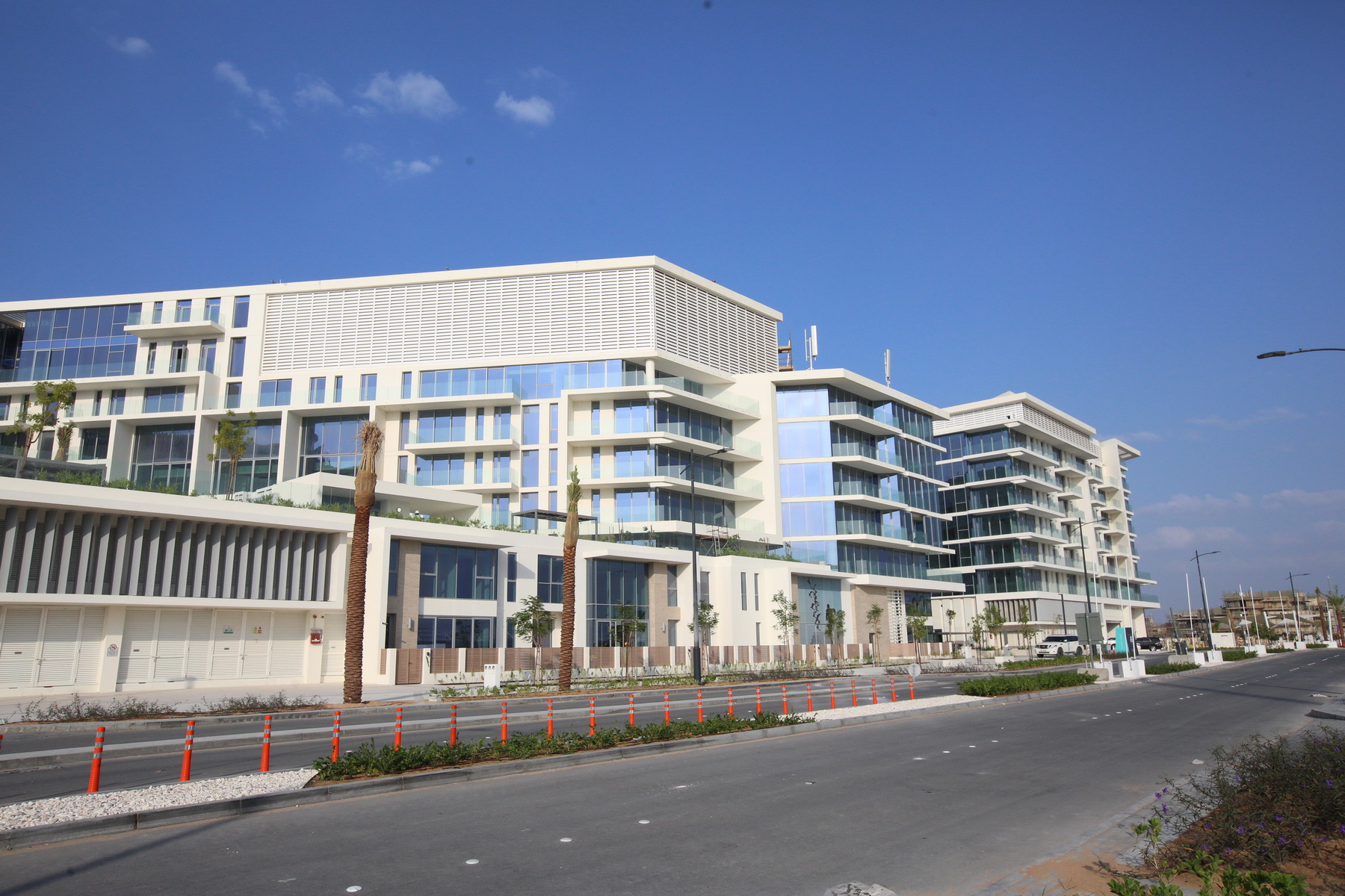 Exterior view of Mamsha’s modern architectural façade with glass balconies and waterfront access