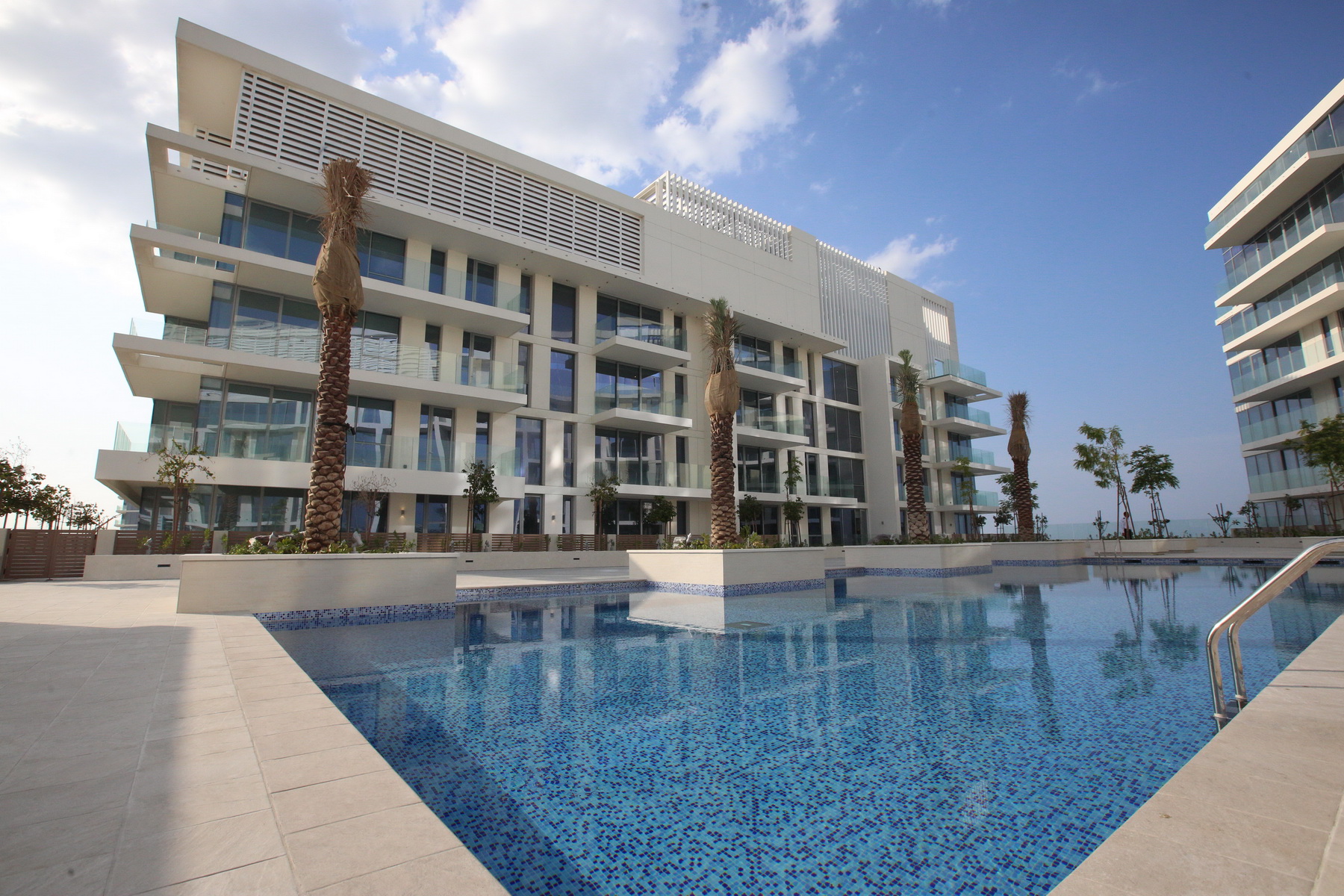 Sunset shot of Mamsha AlSaadiyat with warmly lit exteriors and vibrant evening atmosphere