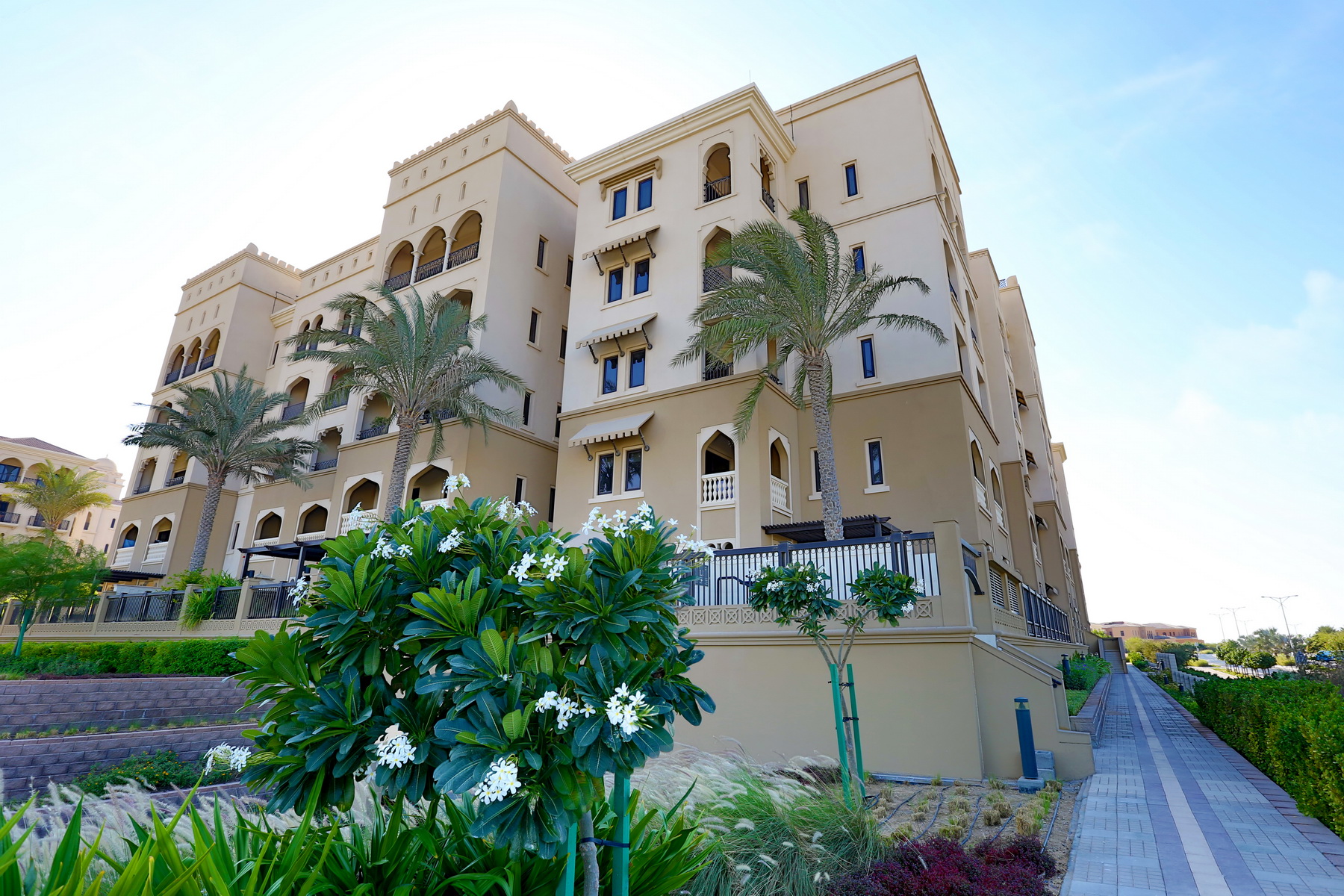 Saadiyat Beach Residences exterior featuring warm‑toned architecture and lush courtyard landscaping.
